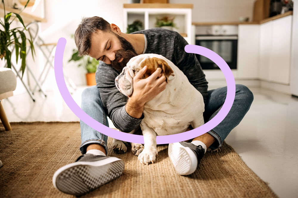 Young bearded man bonding with his english bulldog